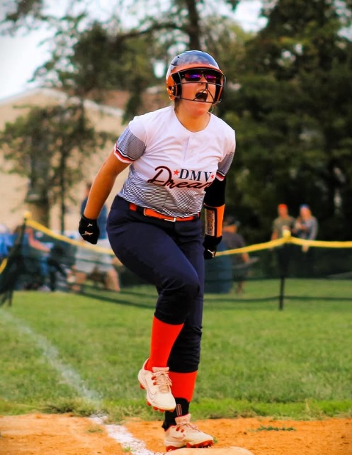 Softball pitcher mid-throw during a high school game